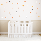 Blossom Confetti flower and dot wall decals arranged on a white nursery wall in soft peach and terracotta tones.