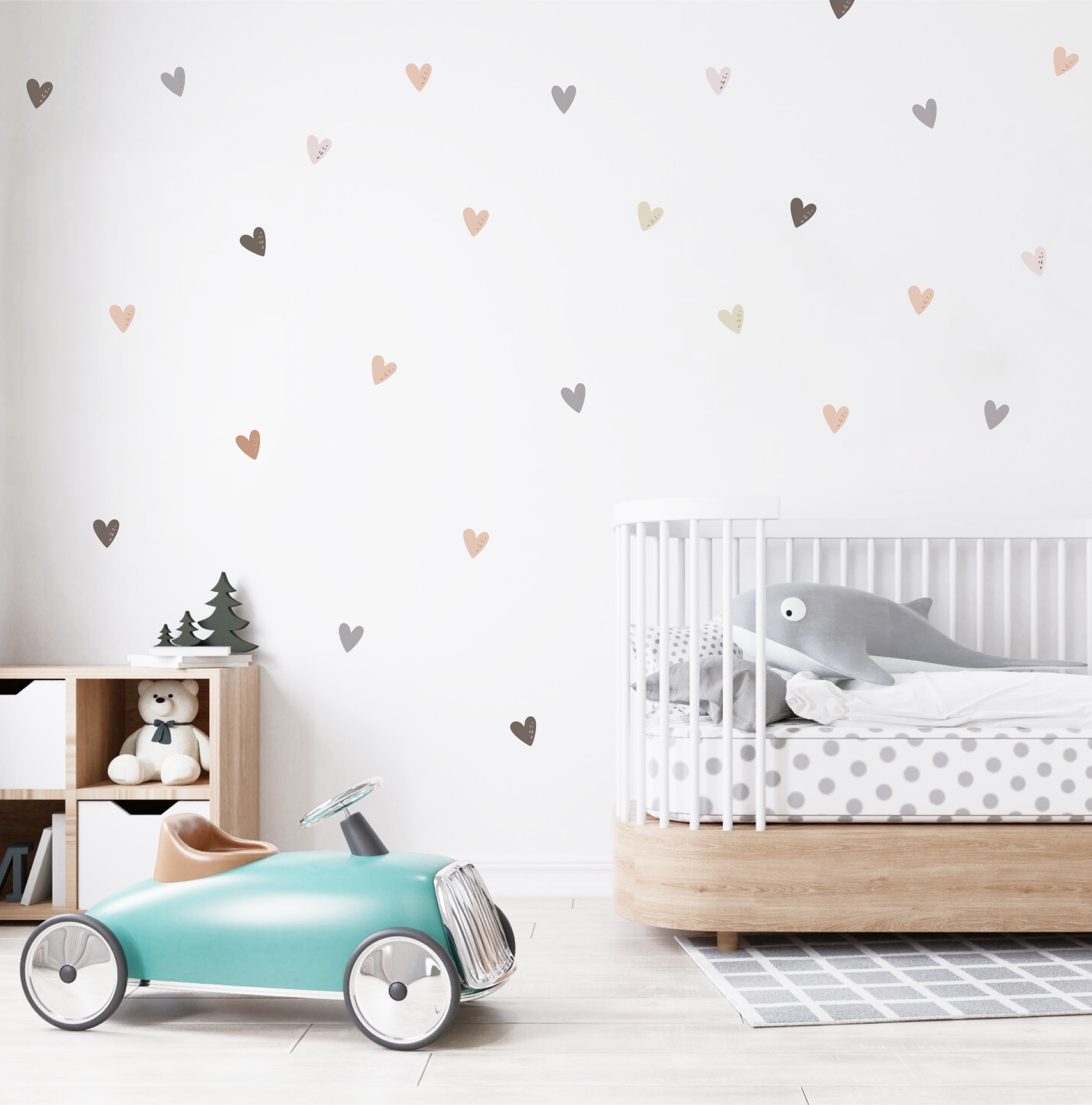 Soft neutral-tone heart decals scattered on a nursery wall above a wooden toy shelf and teddy bear