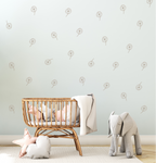 Boho nursery with rattan crib and dandelion wall decals in soft neutral tones