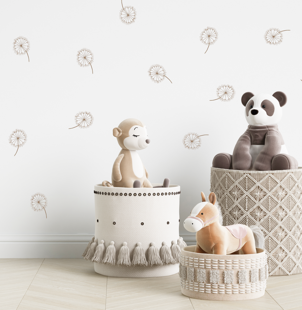 Stuffed animals in woven baskets against a white wall decorated with dandelion decals