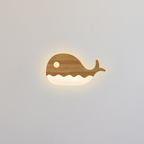 Close-up of wooden whale wall lamp with warm LED light for nursery decor